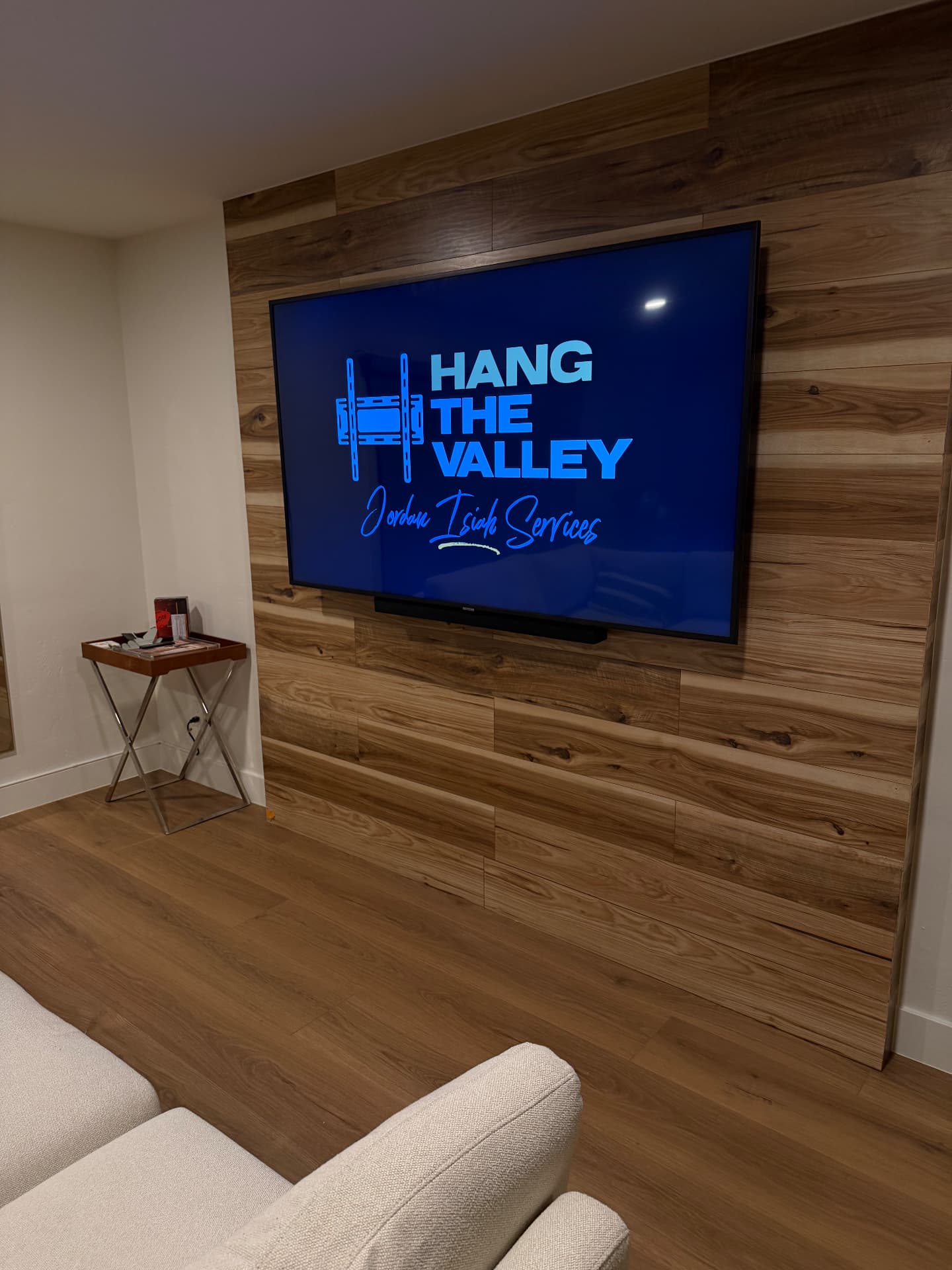 TV mounted on a wood-plank accent wall with a soundbar below